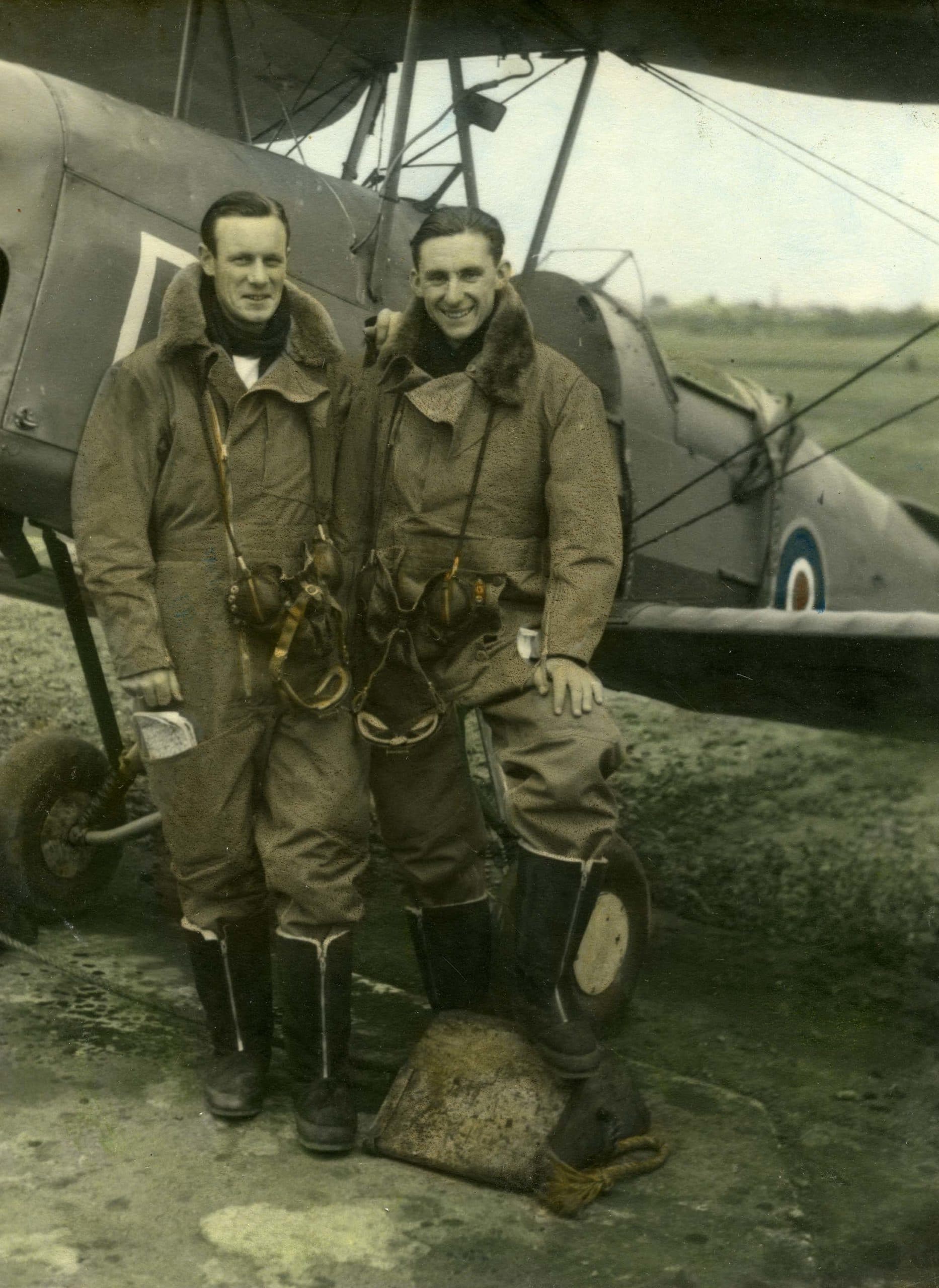 FAA Pilots SLT (A) Rod Thompson RNZNVR & SLT (A) J. Pollock RNZNVR in full flying kit beside a Tiger Moth Trainer at RNZAS Elmdon - now Birmingham Airport