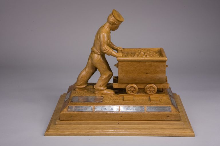 FT 0230 Coal miners strike carving Carving depicting a rating pushing a coal truck.